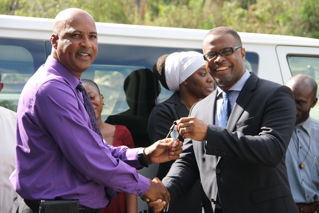 Minister of Culture in the Nevis Island Administration Hon. Mark Brantley handing over the keys of a new Toyota bus to Chief Executive Officer of the Nevis Cultural Development Foundation Keith Scarborough while the Foundation’s staff looks on June 11, 201